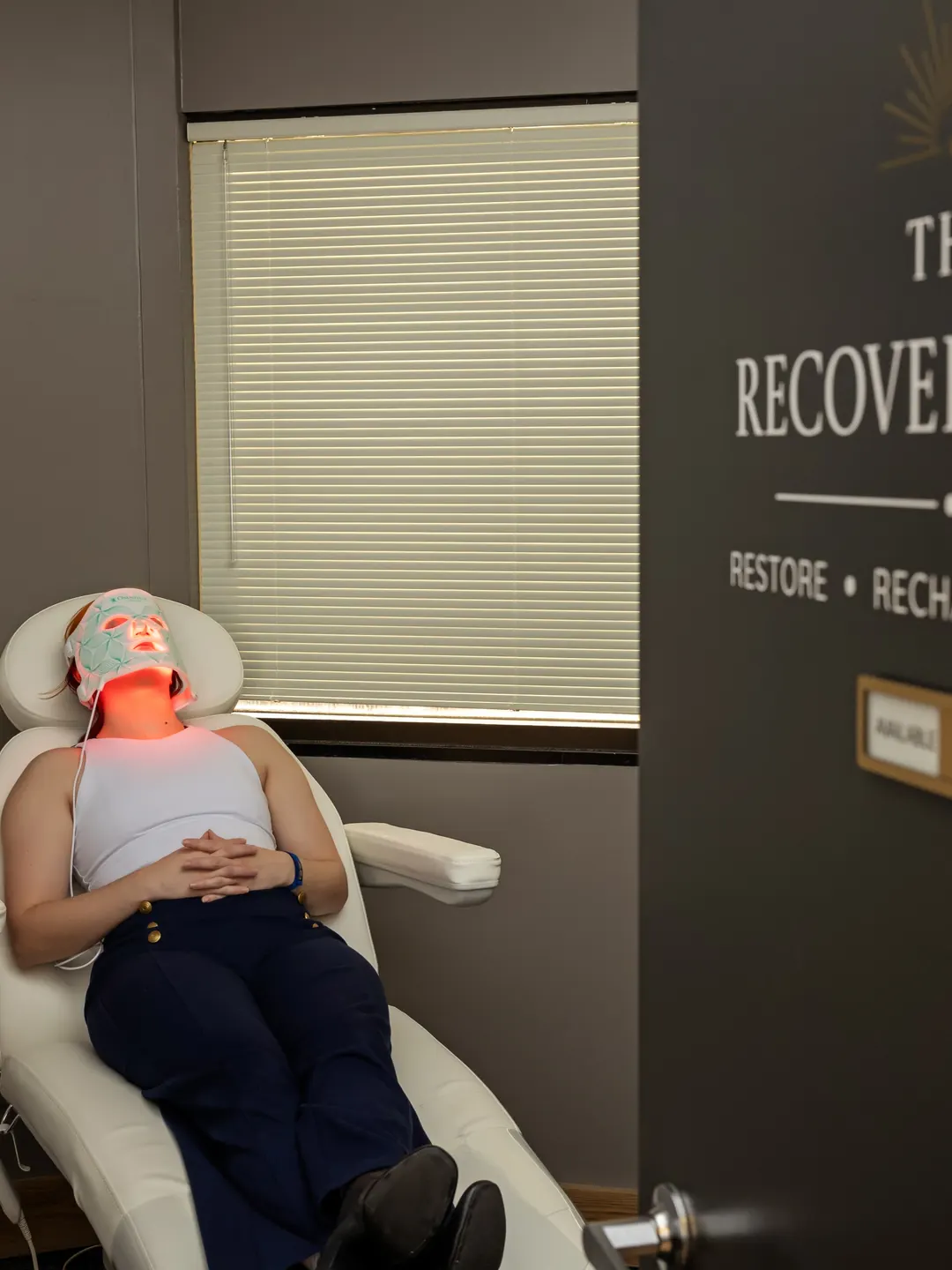 The Recovery Suite, with a patient reclining under a red LED light therapy mask