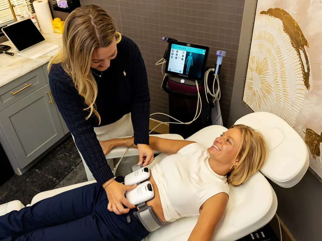A treatment room with a reclining chair and an EMS console, during a muscle toning session