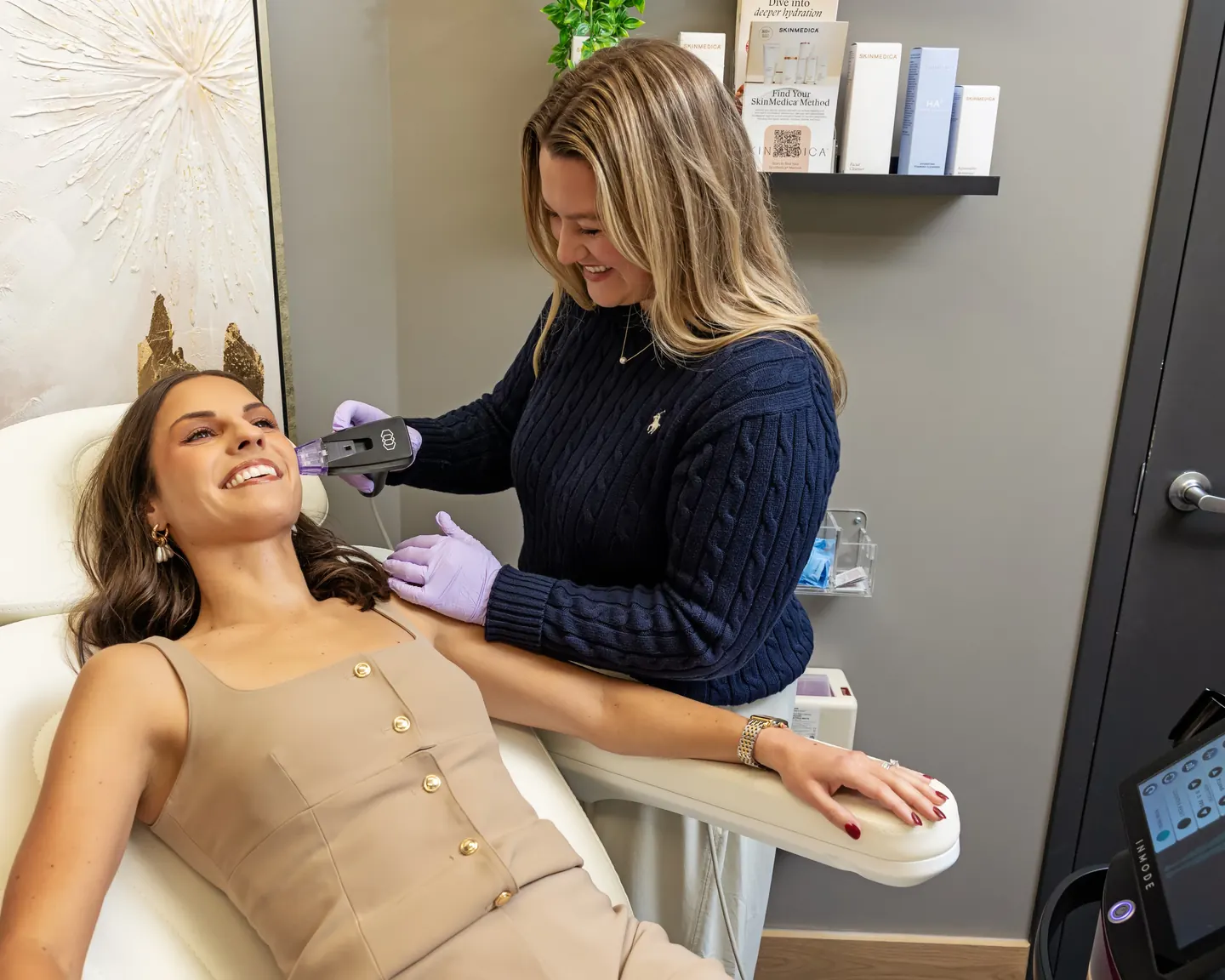 A provider treating a smiling patient’s jawline with a Morpheus8 handpiece